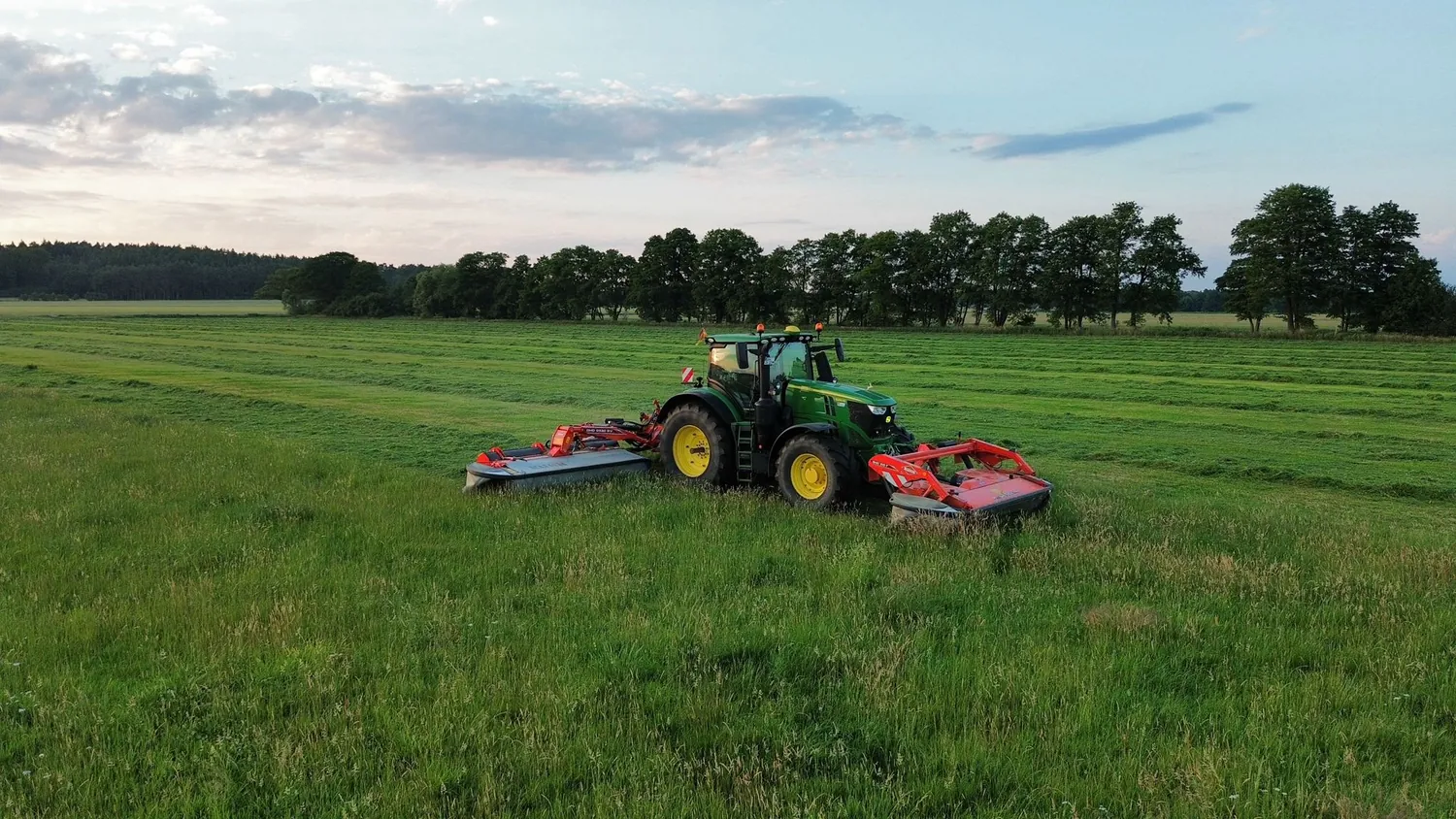 Traktor mit Mähtechnik auf einer Grünlandfläche